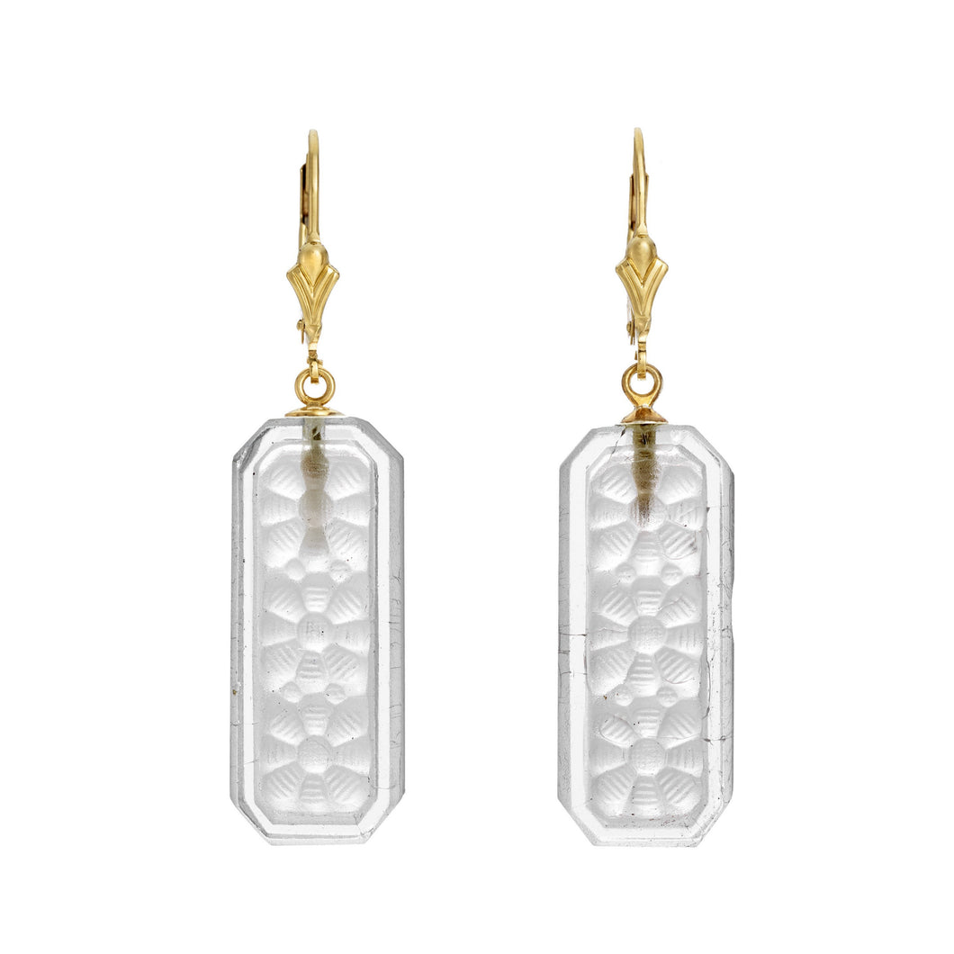 Earrings with gold plate ear hooks, rectangular pieces of clear glass dangling from the hooks. Glass has a floral motif.